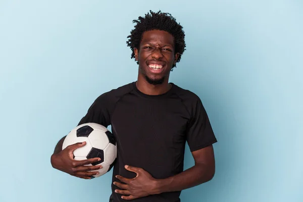 Joven Afroamericano Jugando Fútbol Aislado Sobre Fondo Azul Riendo Divirtiéndose —  Fotos de Stock