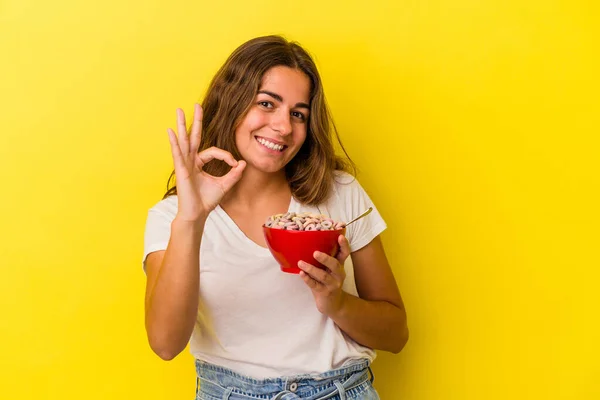 Jovem Caucasiana Segurando Cereais Isolados Fundo Amarelo Alegre Confiante Mostrando — Fotografia de Stock