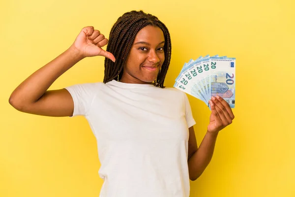 Mladá Afroameričanka Drží Bankovky Izolované Žlutém Pozadí Cítí Hrdost Sebevědomí — Stock fotografie
