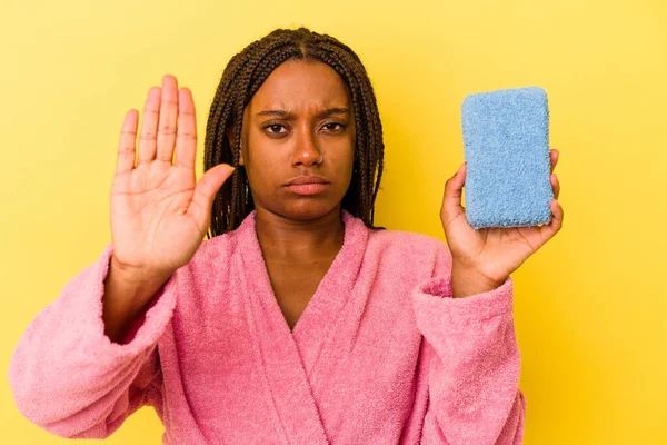 Young African American Woman Wearing Bathrobe Holding Blue Sponge Isolated — 图库照片