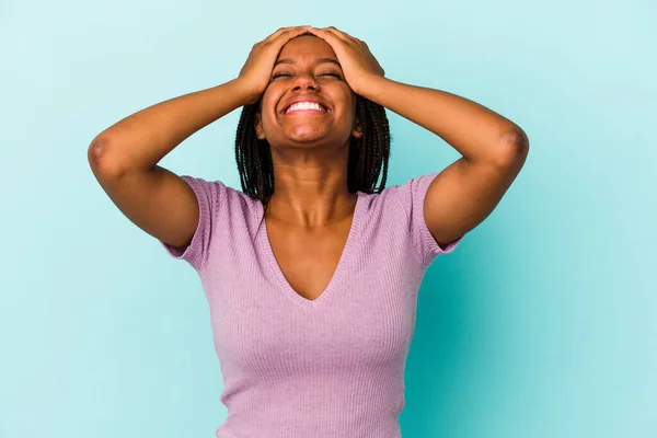Młoda Afroamerykanka Odizolowana Niebieskim Tle Śmieje Się Trzymając Ręce Głowie — Zdjęcie stockowe
