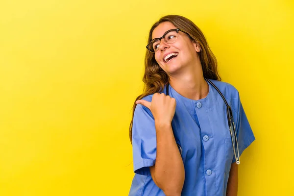 Young Nurse Woman Isolated Yellow Background Points Thumb Finger Away — Stock Photo, Image