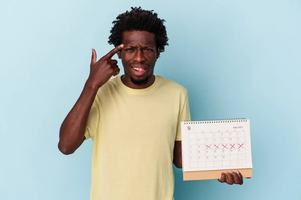 Jonge Afro Amerikaanse Man Houdt Kalender Geïsoleerd Blauwe Achtergrond Toont — Stockfoto