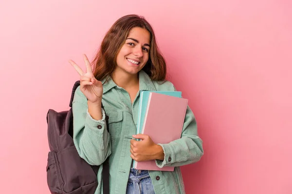 若いですCaucasian学生女性保持本隔離上のピンクの背景ショーナンバー2とともに指 — ストック写真