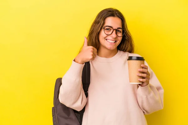 Joven Estudiante Caucásica Sosteniendo Café Aislado Sobre Fondo Amarillo Sonriendo — Foto de Stock