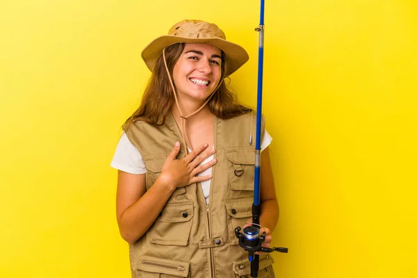 Young Caucasian Fisherwoman Holding Rod Isolated Yellow Background Laughs Out — Stock Photo, Image