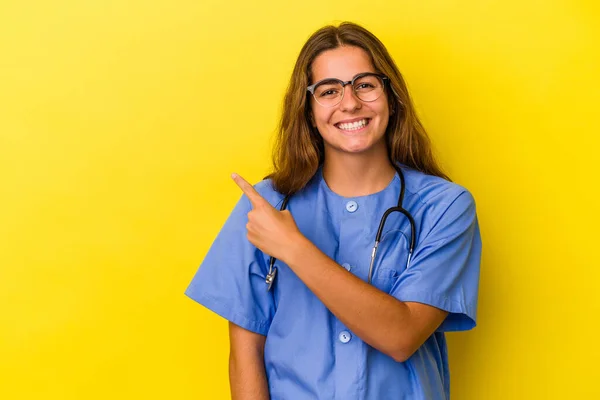 Junge Krankenschwester Isoliert Auf Gelbem Hintergrund Lächelnd Und Zur Seite — Stockfoto
