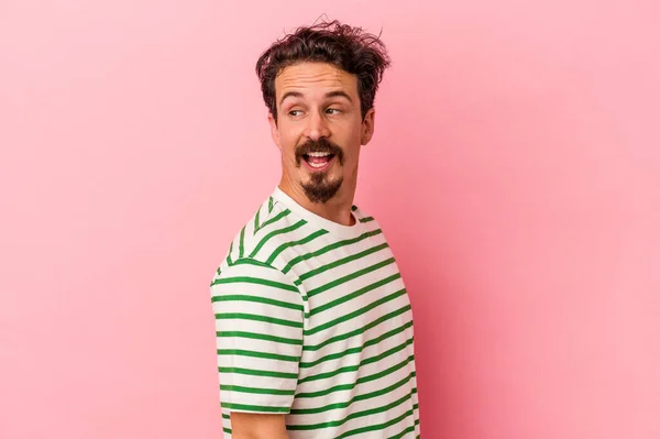 Young Caucasian Man Isolated Pink Background Looks Aside Smiling Cheerful — Stock Photo, Image