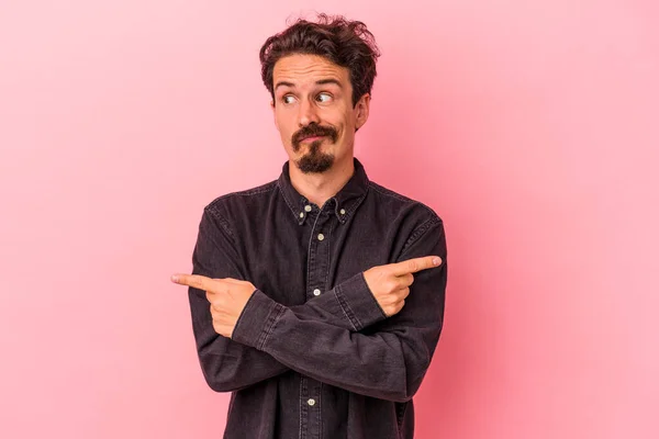 Young Caucasian Man Isolated Pink Background Points Sideways Trying Choose — Stock Photo, Image