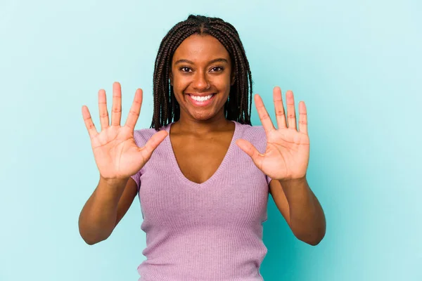 在蓝色背景上被隔离的年轻的非洲裔美国女人 手握十号 — 图库照片