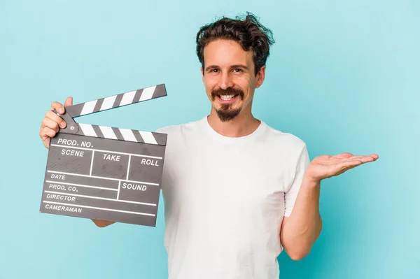 Mladý Kavkazský Muž Drží Clapperboard Izolované Modrém Pozadí Zobrazující Kopírovací — Stock fotografie