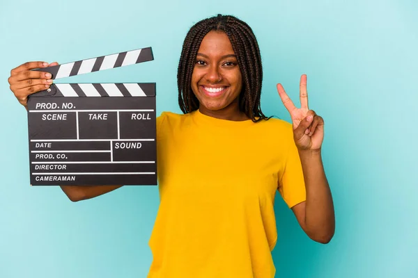 Mladý Africký Američan Žena Drží Clapperboard Izolované Modrém Pozadí Ukazující — Stock fotografie