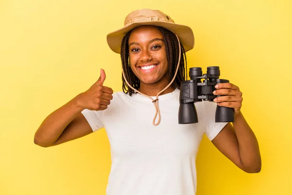 Молода Афроамериканська Дослідниця Тримає Бінокль Ізольований Жовтому Фоні Посміхається Піднімає — стокове фото