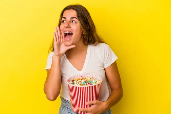 Mujer Joven Caucásica Sosteniendo Palomitas Aisladas Sobre Fondo Amarillo Gritando —  Fotos de Stock