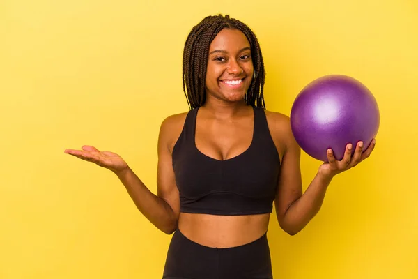 Ung Afrikansk Amerikansk Kvinna Håller Pilates Boll Isolerad Gul Bakgrund — Stockfoto