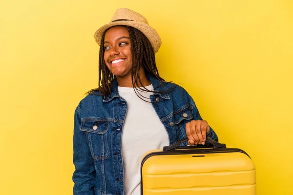Молода Афроамериканська Мандрівниця Тримає Валізу Ізольовану Жовтому Фоні Дивиться Убік — стокове фото