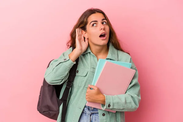 Jovem Estudante Caucasiano Segurando Livros Isolados Fundo Rosa Tentando Ouvir — Fotografia de Stock