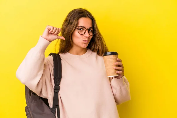 Jovem Estudante Caucasiano Segurando Café Isolado Fundo Amarelo Sente Orgulhoso — Fotografia de Stock