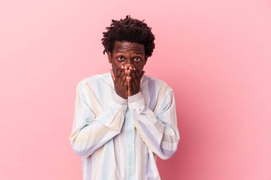 Genç Afrikalı Amerikalı bir adam pembe arka planda izole edilmiş ağzı kapalı ve endişeli görünüyor..