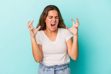 Mavi arka planda izole edilmiş beyaz bir kadın öfkeyle bağırıyor..
