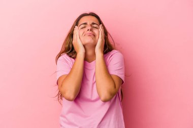 Pembe arka planda izole edilmiş beyaz bir kadın ağlıyor, bir şeyden mutsuz, acı ve kafa karışıklığı konsepti..