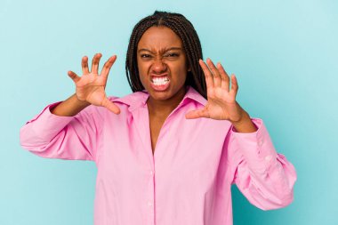 Genç Afrikalı Amerikalı kadın mavi arka planda izole edilmiş gergin ellerle çığlık atıyor..