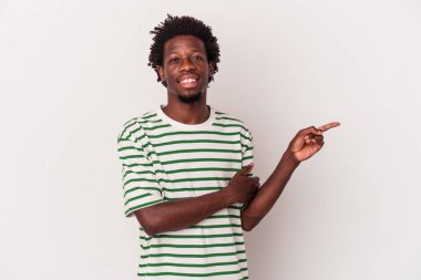 Beyaz arka planda izole edilmiş genç bir Afrikalı Amerikalı işaret parmağıyla işaret ederek gülümsüyor..