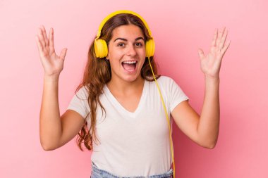 Pembe arka planda müzik dinleyen beyaz bir kadın hoş bir sürprizle karşılaşıyor, heyecanlı ve el kaldırıyor..