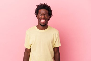 Genç Afrikalı Amerikalı bir adam pembe arka planda izole edilmiş komik ve dost canlısı bir dil kullanıyor..