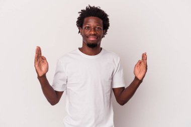 Genç Afro-Amerikalı adam beyaz arka planda izole edilmiş. Elinde parmakları olan, gülümseyen ve kendinden emin bir şey var..