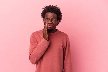 Genç Afrikalı Amerikalı bir adam pembe arka planda izole edilmiş güçlü bir diş ağrısı ve azı dişi ağrısı var..