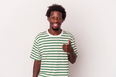Genç Afrikalı Amerikalı adam beyaz arka planda izole edilmiş gülümsüyor ve başparmağını kaldırıyor.