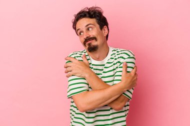 Kafkasyalı genç adam pembe arka planda izole edilmiş, güler yüzlü, kaygısız ve mutlu..