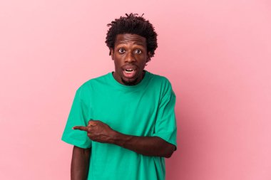 Pembe arka planda izole edilmiş genç Afro-Amerikan bir adam.