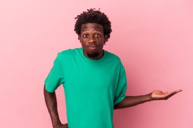 Pembe arka planda izole edilmiş genç Afro-Amerikalı bir adam bir avuç içinde fotokopi alanı ve belinde başka bir el tutuyor..