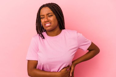 Genç Afrikalı Amerikalı kadın, pembe arka planda izole edilmiş, karaciğer ağrısı, mide ağrısı var..