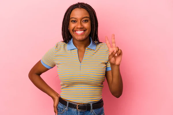 年轻的非洲裔美国女子 身披粉红的背景 显示出胜利的迹象 面带微笑 — 图库照片