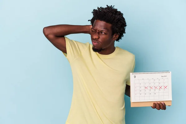 Jonge Afro Amerikaanse Man Houdt Kalender Geïsoleerd Blauwe Achtergrond Raken — Stockfoto