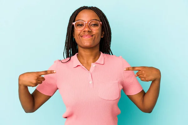 年轻的非洲裔美国女人 与蓝色背景的人隔离 手指衬衫的复制品空间 自豪而自信 — 图库照片