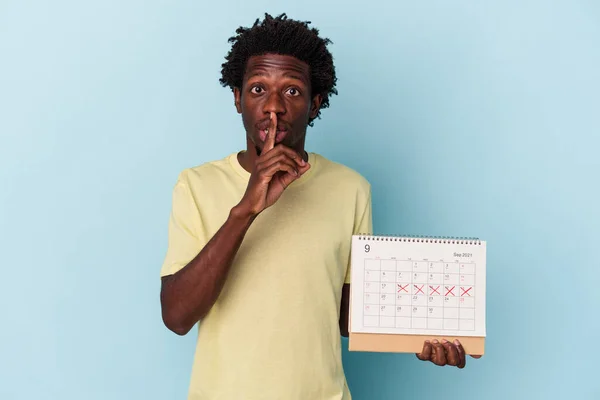 Mladý Africký Američan Drží Kalendář Izolované Modrém Pozadí Držet Tajemství — Stock fotografie