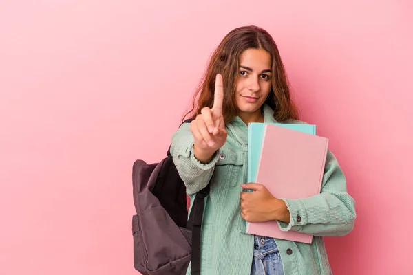 年轻的高加索女学生手里拿着用粉色背景隔开的书 带着第一个手指 — 图库照片