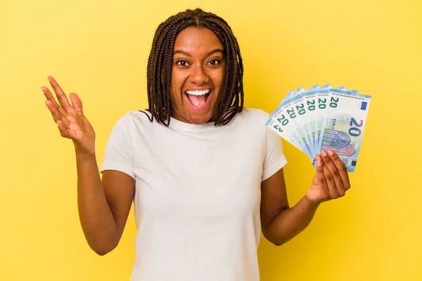 Mladá Afroameričanka Drží Bankovky Izolované Žlutém Pozadí Dostává Příjemné Překvapení — Stock fotografie