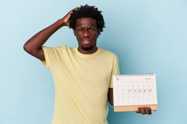 Jonge Afro Amerikaanse Man Houdt Kalender Geïsoleerd Blauwe Achtergrond Wordt — Stockfoto