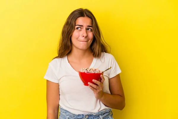 Mulher Caucasiana Jovem Segurando Cereais Isolados Fundo Amarelo Confuso Sente — Fotografia de Stock