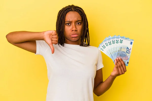 Mladá Afroameričanka Držící Bankovky Izolované Žlutém Pozadí Ukazující Gesto Nelibosti — Stock fotografie