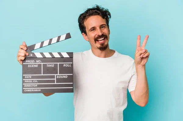 Young Caucasian Man Holding Clapperboard Isolated Blue Background Joyful Carefree — Stock Photo, Image