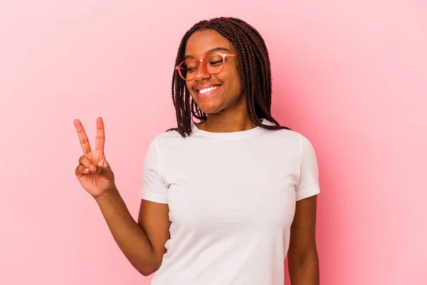 年轻的非洲裔美国女人 背景是粉色的 快乐而无忧无虑 手握和平的象征 — 图库照片