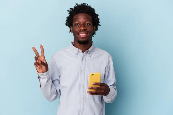 年轻的非洲裔美国人 手持蓝色背景的手机 手指头拿着二号 — 图库照片