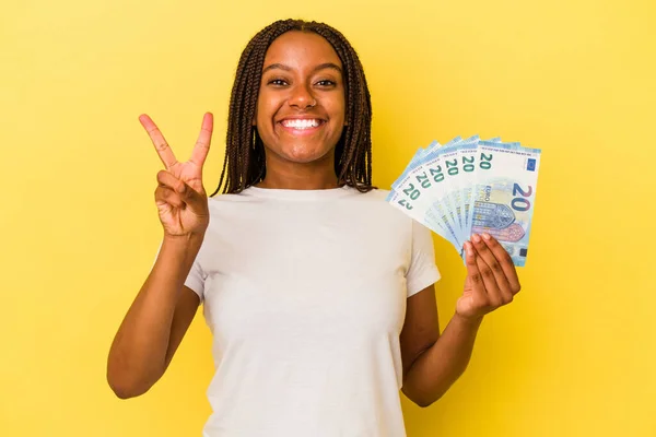 Mladá Africká Američanka Drží Bankovky Izolované Žlutém Pozadí Ukazující Číslo — Stock fotografie