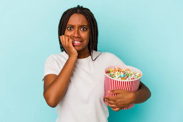 Young African American Woman Eating Pop Corns Isolated Blue Background — Stockfoto
